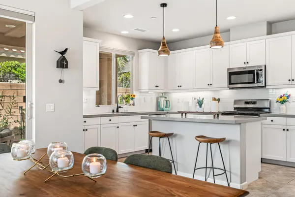 a kitchen with granite countertop a stove a sink and a refrigerator