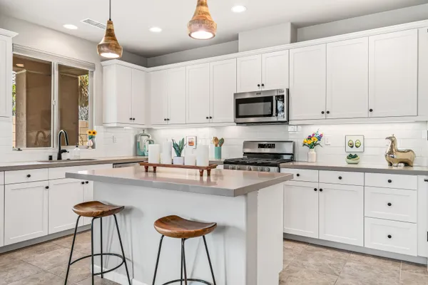 a kitchen with granite countertop white cabinets and stainless steel appliances