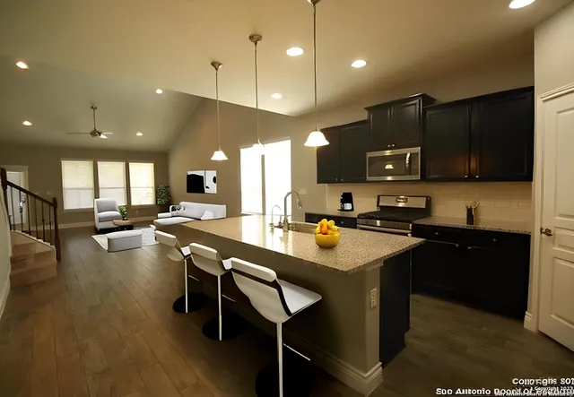 a kitchen with granite countertop stainless steel appliances and wooden cabinets