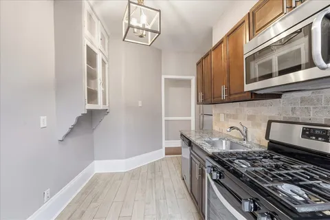 a kitchen with stainless steel appliances granite countertop a stove and a microwave