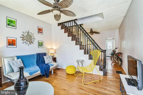 a living room with couches a dining table and chairs with wooden floor