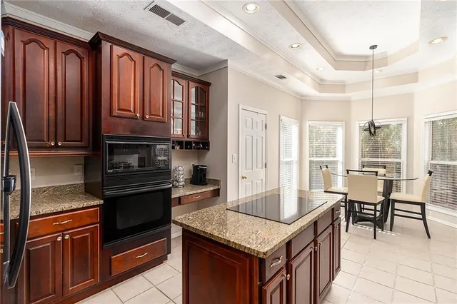 a kitchen with granite countertop a stove refrigerator and cabinets