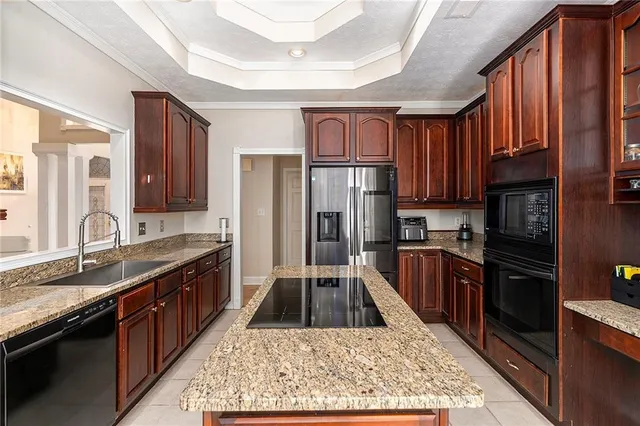 a kitchen with granite countertop a refrigerator stove and sink