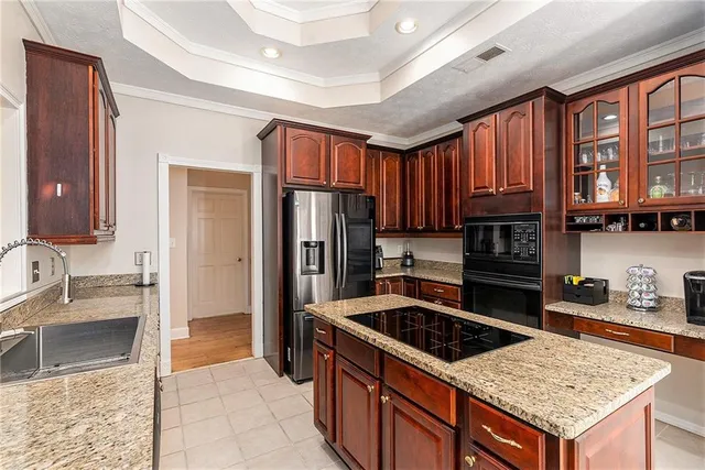 a kitchen with granite countertop a sink stove and refrigerator