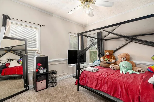 a bedroom with a bed and a tv on the wall