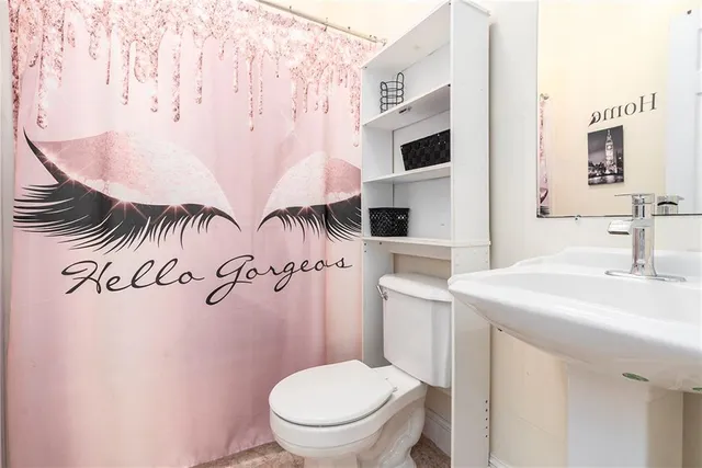 a bathroom with a sink mirror vanity and toilet