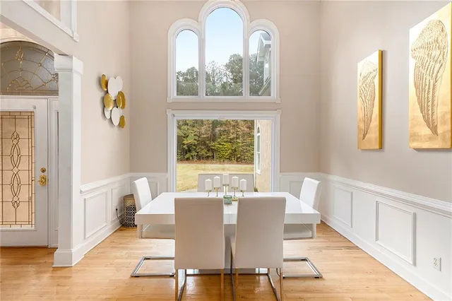 a view of a dining room with furniture a rug and wooden floor