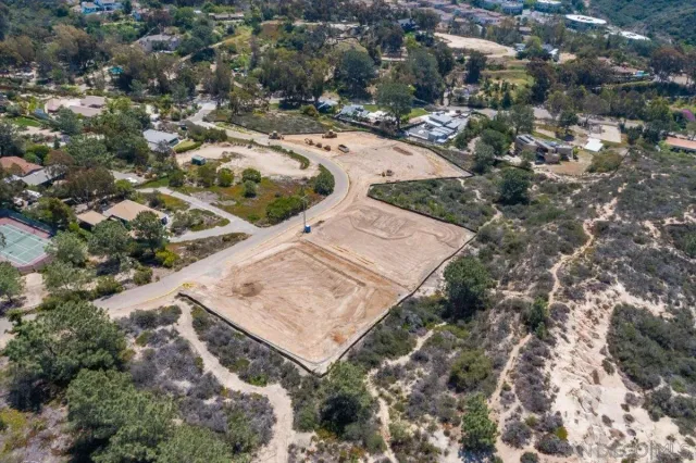 an aerial view of a house with a yard and mountain