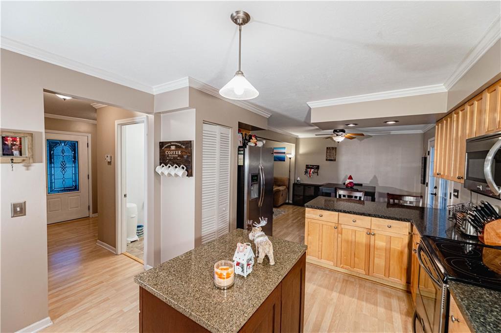 3673 Mitchell Road New Castle, PA 16105 - Photo 6 of 25 a kitchen island with stainless steel appliances granite countertop a refrigerator a stove and a sink