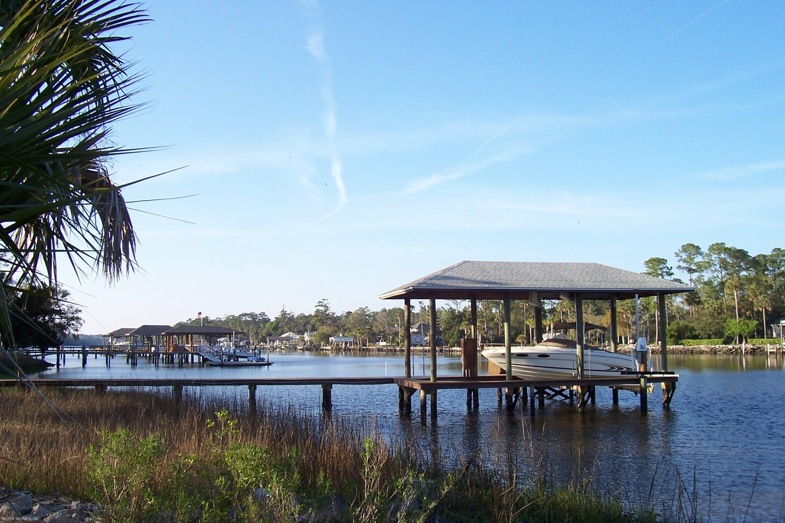 200 Clatter Bridge Road Ponte Vedra Beach, FL 32081 - Photo 12 of 12 a view of a lake with a table and chairs under an umbrella