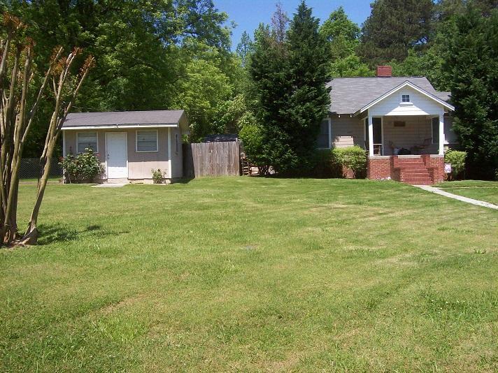 25 Gaines Road Northeast Rome, GA 30161 - Photo 1 of 1 a front view of a house with a garden and trees