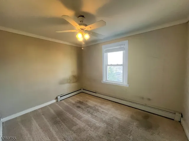 an empty room with a window and a fan