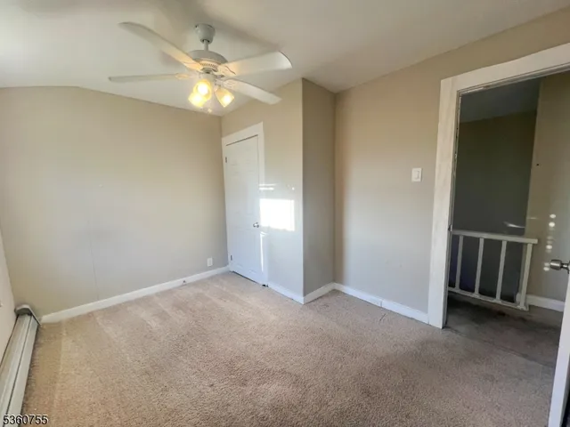 an empty room with closet and a chandelier fan