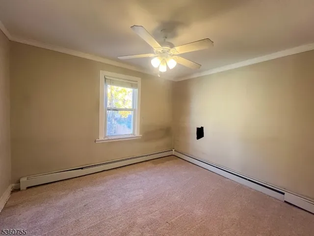 an empty room with a window and ceiling fan