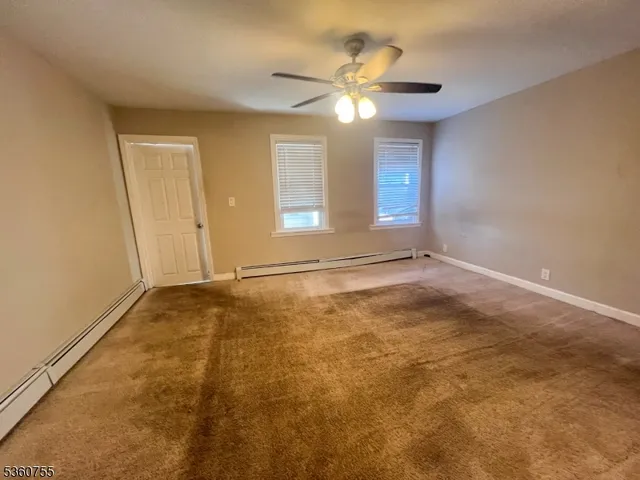 an empty room with a ceiling fan and window
