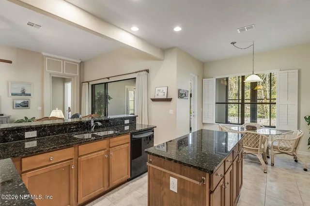 a living room with furniture kitchen view and a chandelier