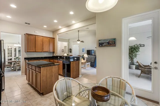 a kitchen with stainless steel appliances granite countertop a stove a sink a microwave a refrigerator and white cabinets