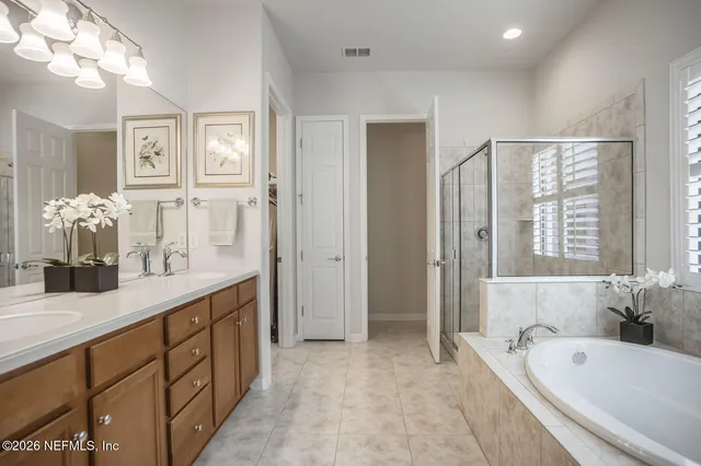 a bedroom with a bed couches and a large window