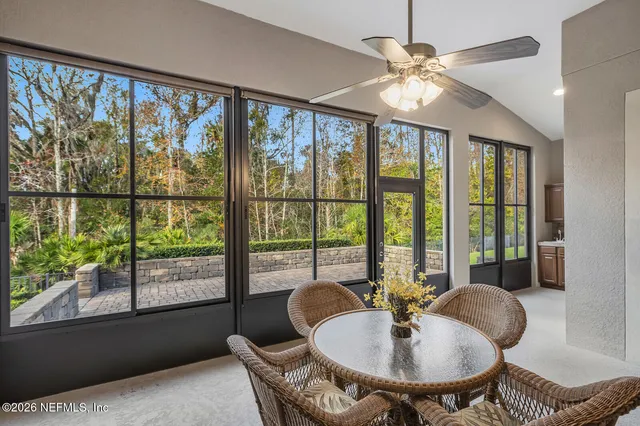 a dining room with furniture a chandelier and glass door