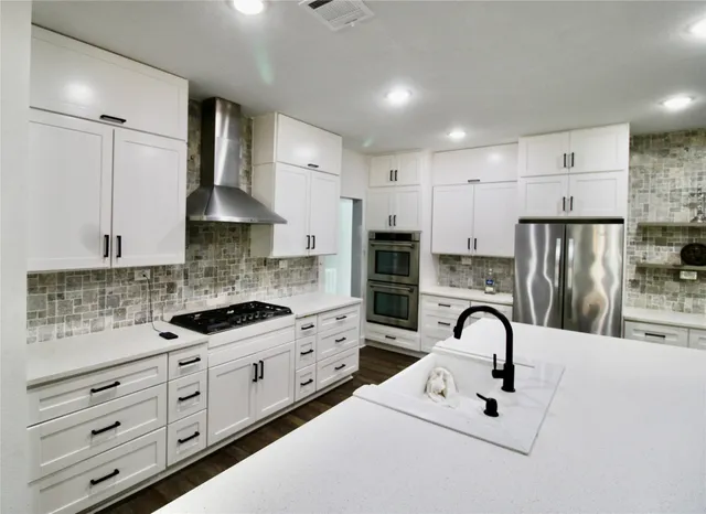 a kitchen with kitchen island a sink appliances and cabinets
