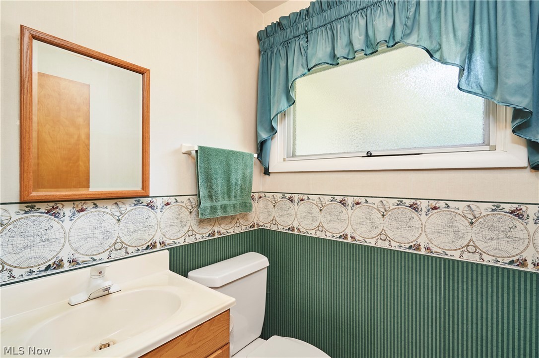 299 West Caston Road New Franklin, OH 44319 - Photo 18 of 23 Bathroom featuring a wood-finish vanity with an integrated sink and a framed wall mirror