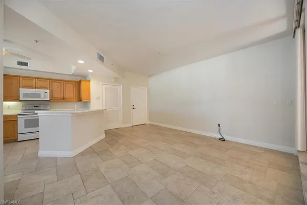 a view of a kitchen with microwave and white cabinets