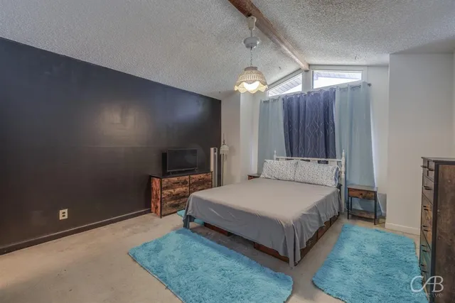 a spacious bedroom with a bed and a mirror