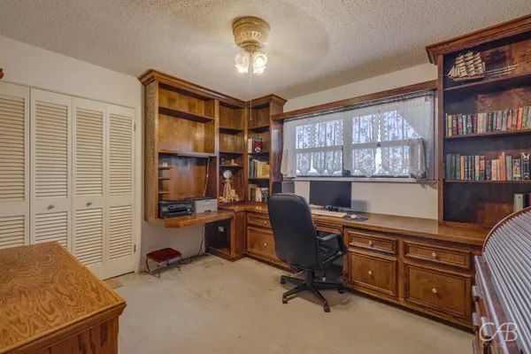 a view of a workspace with furniture and a window