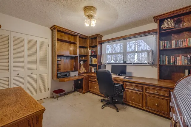 a view of a workspace with furniture and a window