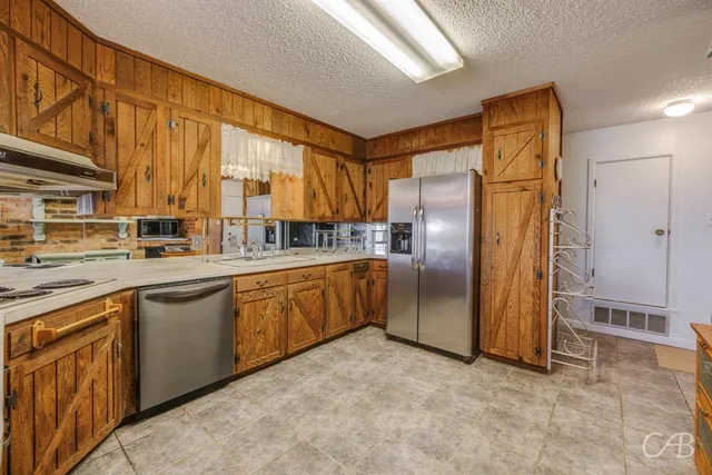 a kitchen with stainless steel appliances granite countertop a refrigerator and a stove