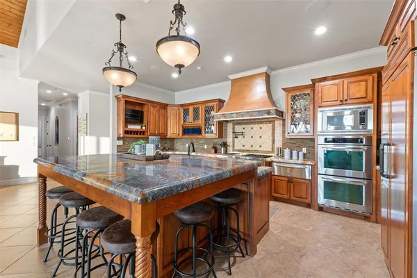 a kitchen with stainless steel appliances granite countertop a sink a stove and a refrigerator