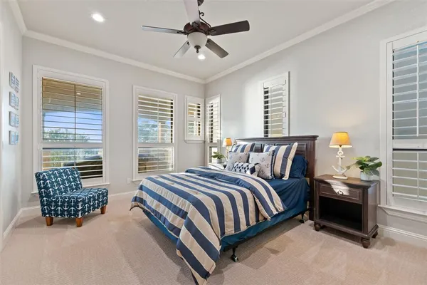 a spacious bedroom with a bed a chandelier and a window