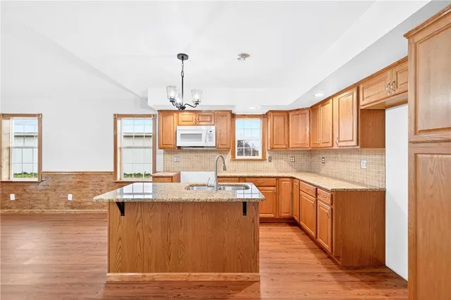 a kitchen with stainless steel appliances granite countertop a sink stove and wooden cabinets
