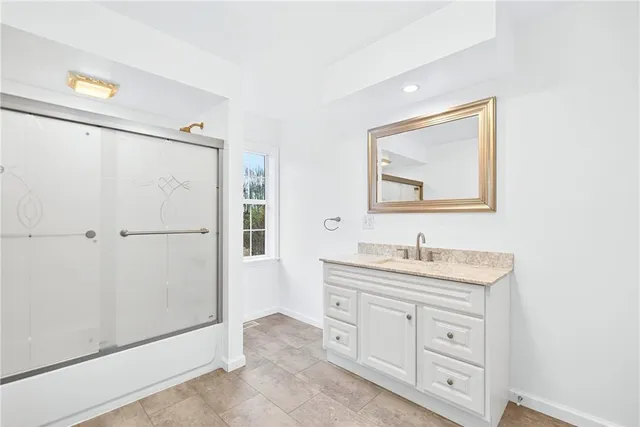 a bathroom with a double vanity sink a toilet a mirror and