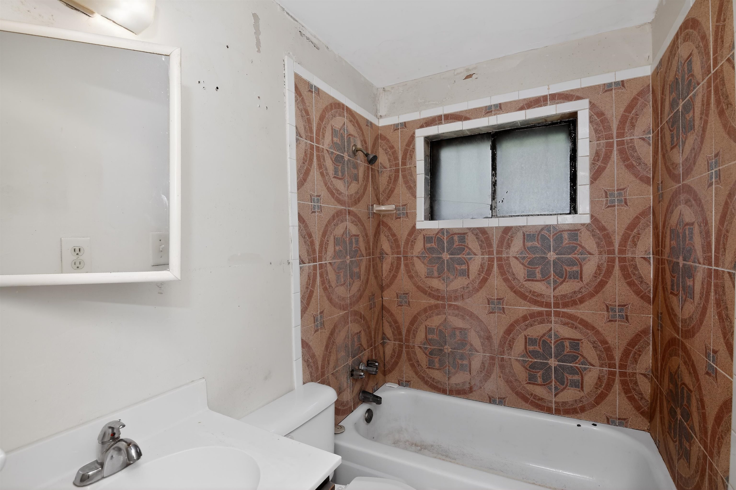 3451 Birdsong Ferry Road Memphis, TN 38118 - Photo 26 of 27 Bathroom featuring a tiled shower/tub combination with patterned ceramic tiles