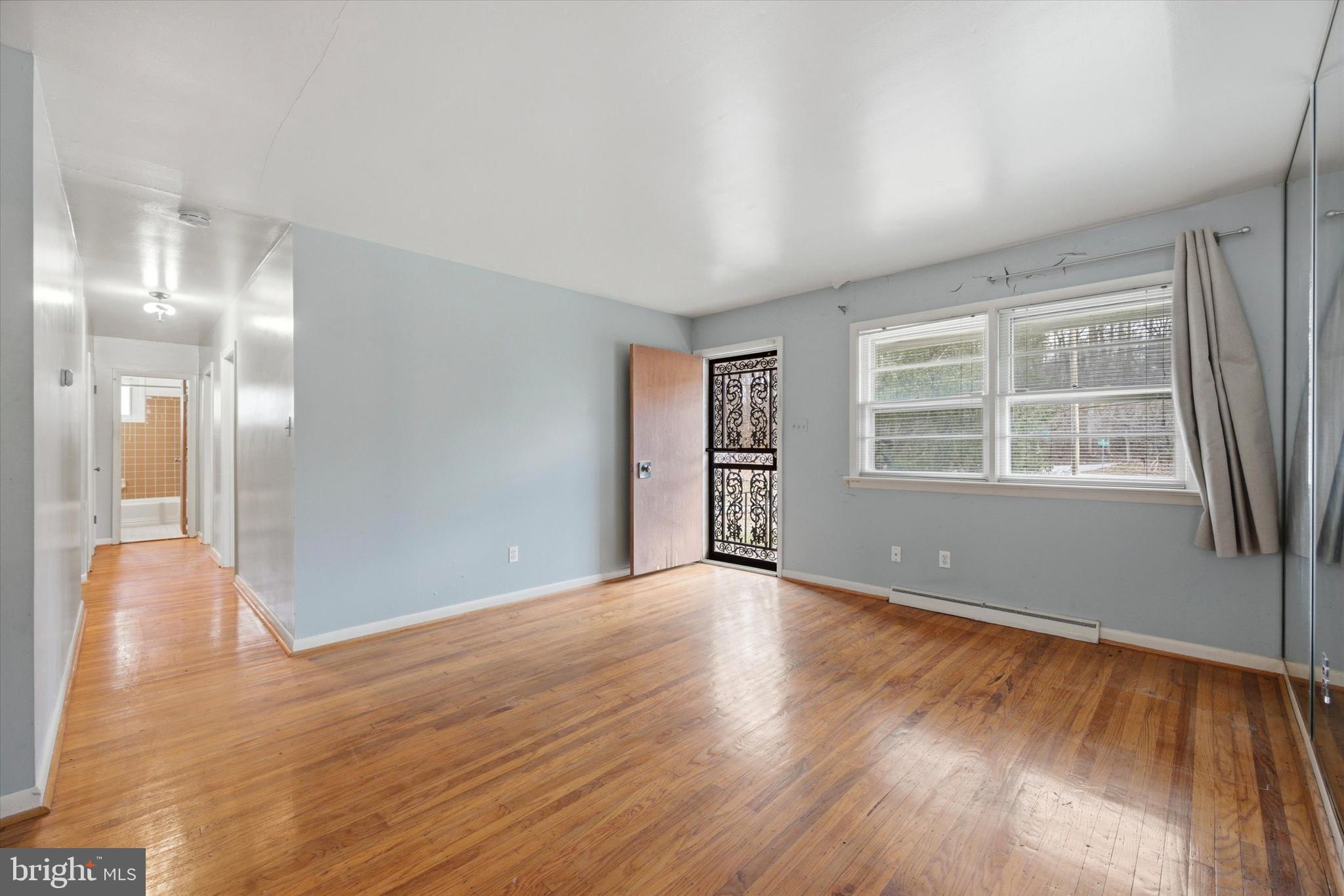129 Locksley Road Glen Mills, PA 19342 - Photo 5 of 36 a view of an empty room with wooden floor and a window
