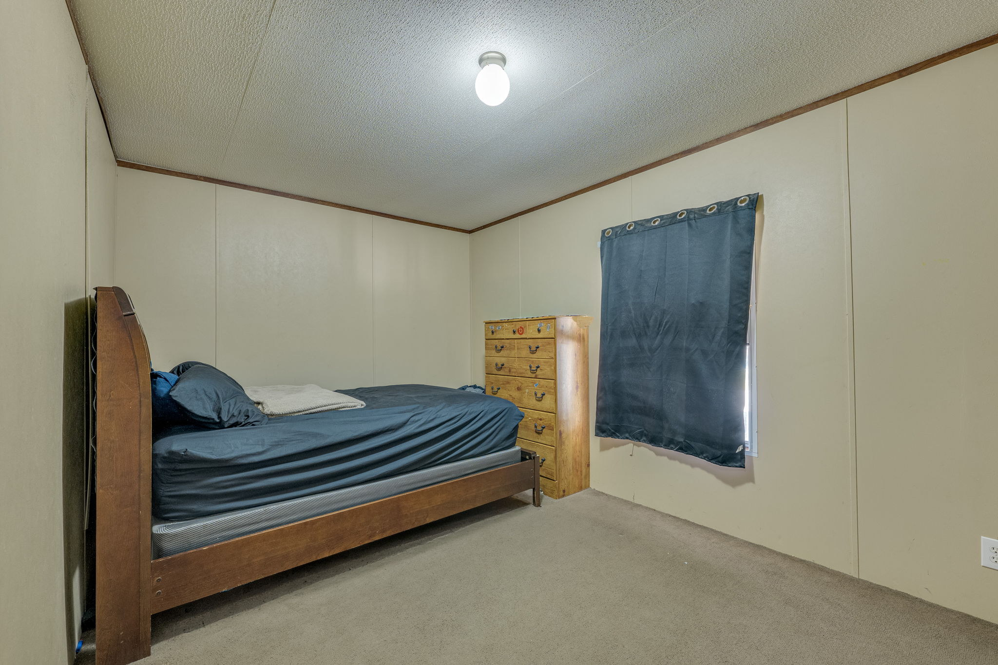 1781 Long Road Lockhart, TX 78644 - Photo 13 of 17 Simple panel walls and neutral carpeting define this cozy bedroom space.