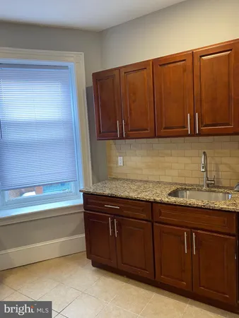 a kitchen with granite countertop a sink and cabinets