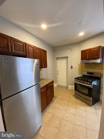a kitchen with stainless steel appliances granite countertop a refrigerator and a stove top oven