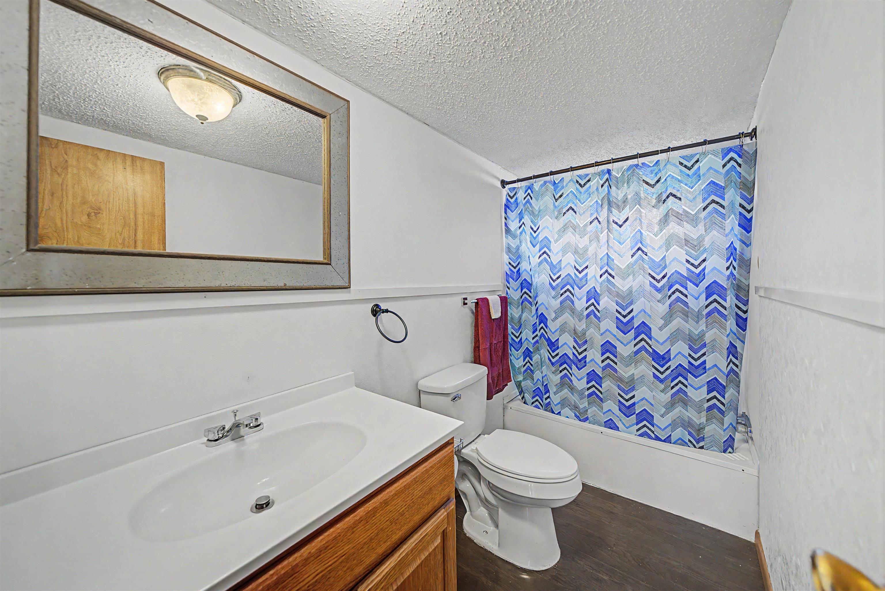 6264 45th Highway South Ramer, TN 38367 - Photo 22 of 24 Bathroom featuring a wood-finish vanity with an integrated sink, polished chrome faucet, and a large wall-mounted mirror
