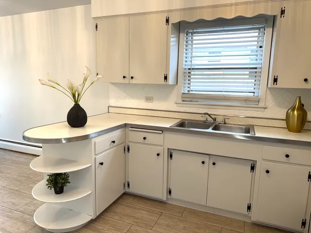 a utility room with cabinets and wooden floor
