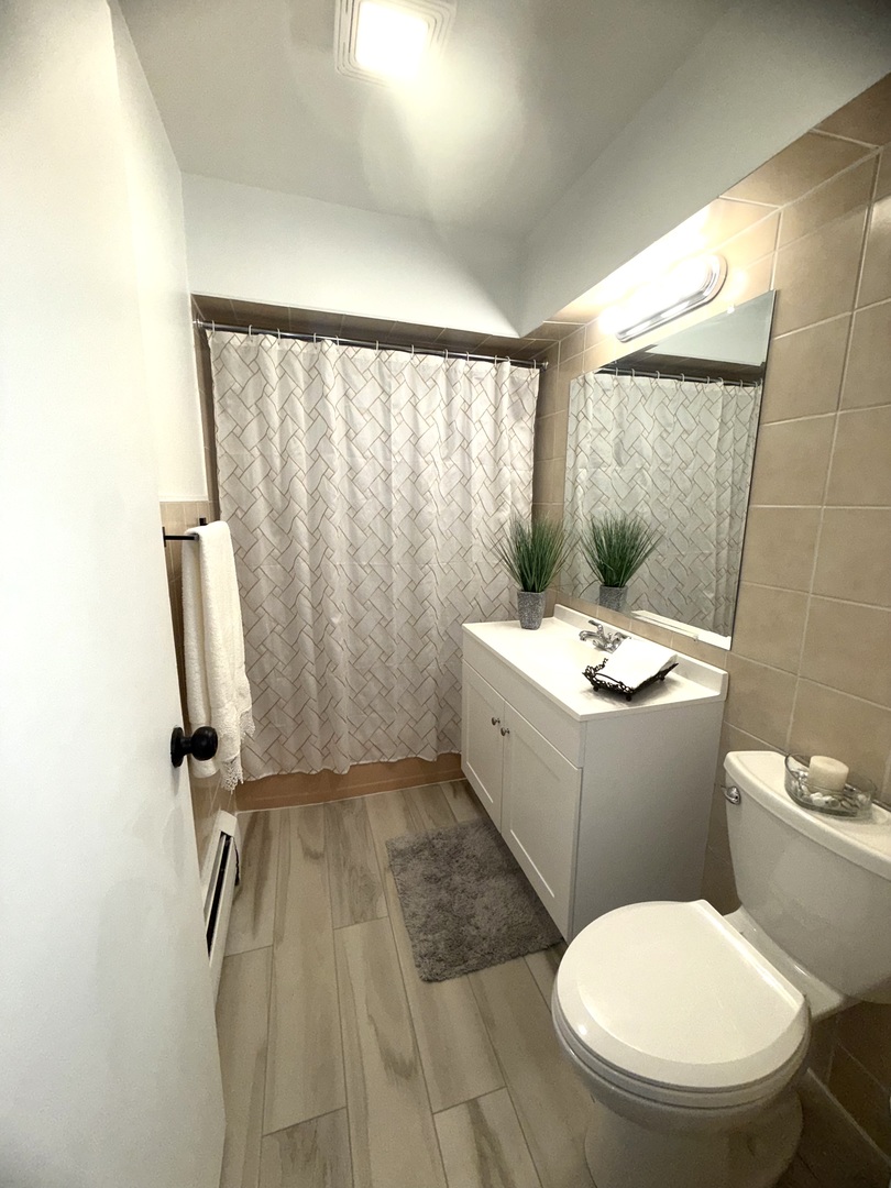 2308 Oakton Street, Unit 1 Park Ridge, IL 60068 - Photo 9 of 11 a bathroom with a sink toilet and shower