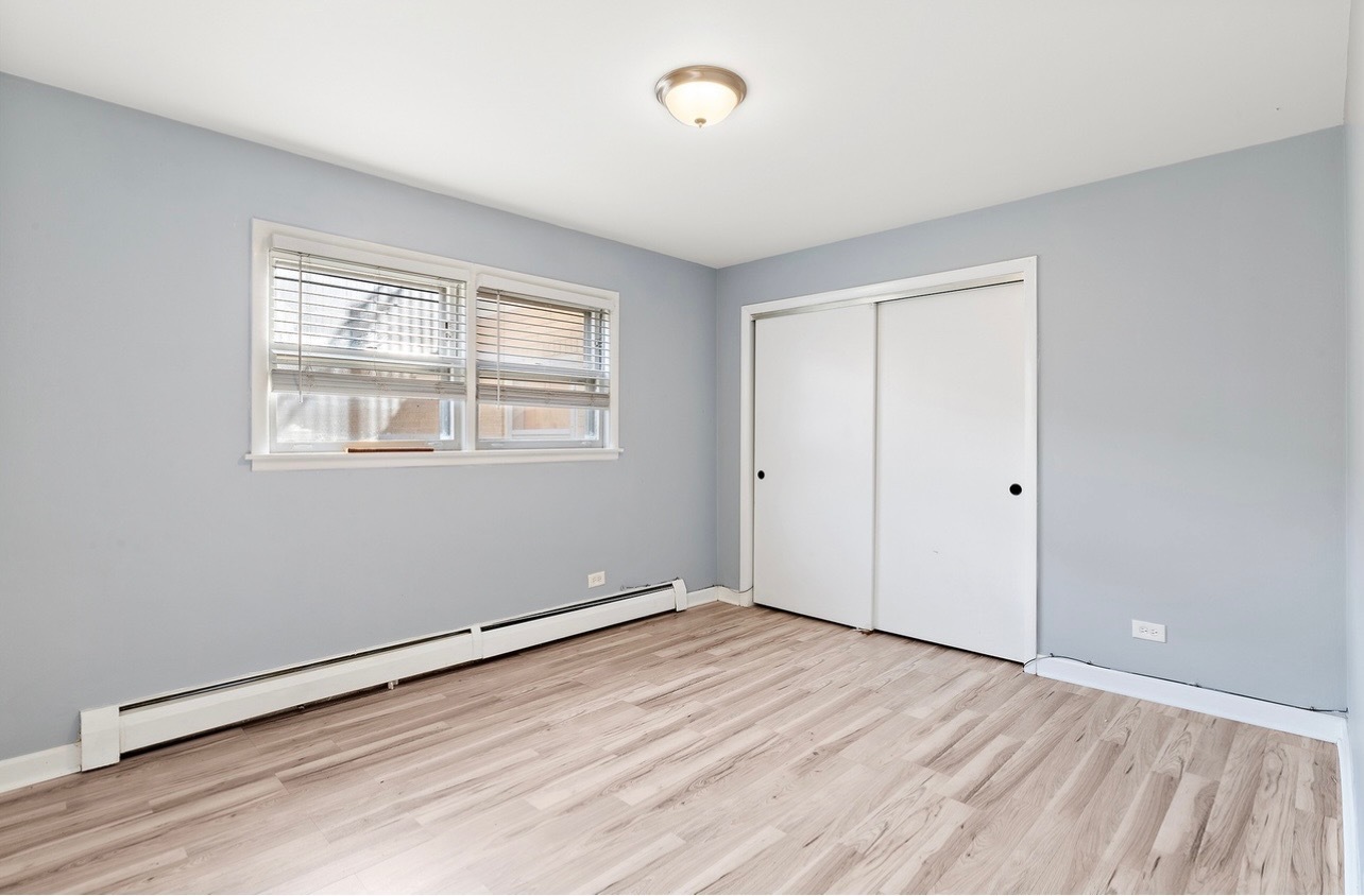 2308 Oakton Street, Unit 1 Park Ridge, IL 60068 - Photo 10 of 11 an empty room with wooden floor and windows