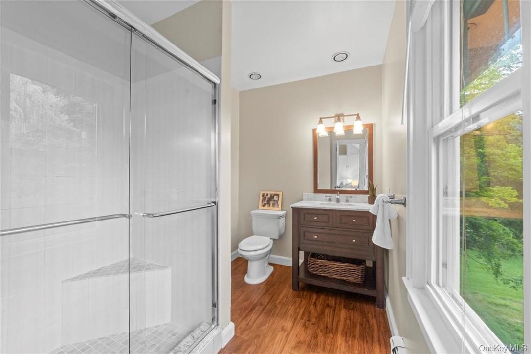 28 Inningwood Road Ossining, NY 10562 - Photo 27 of 37 Bathroom featuring hardwood / wood-style flooring, a shower with door, toilet, and vanity