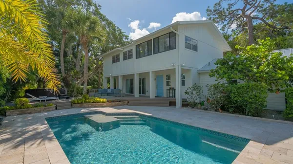 a view of a white house with a yard and plants