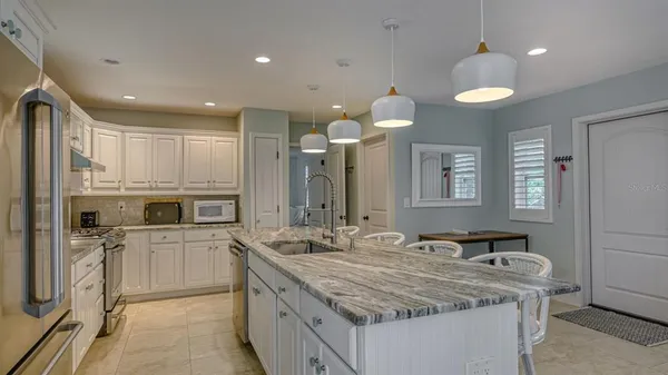 a kitchen with stainless steel appliances granite countertop a sink a stove and a refrigerator