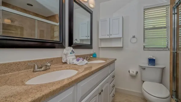 a bathroom with a granite countertop toilet sink and mirror