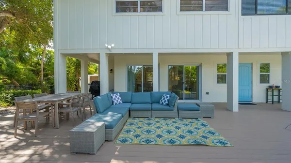 a view of a patio with couches table and chairs and potted plants