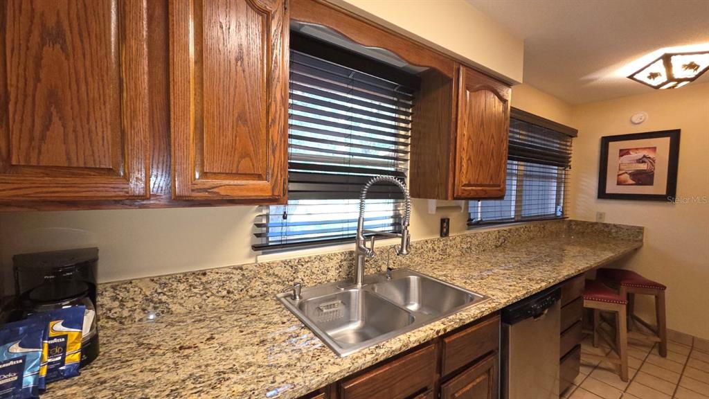454 Cottage Circle, Unit 454 River Ranch, FL 33867 - Photo 8 of 27 a kitchen with kitchen island a sink stove and cabinets