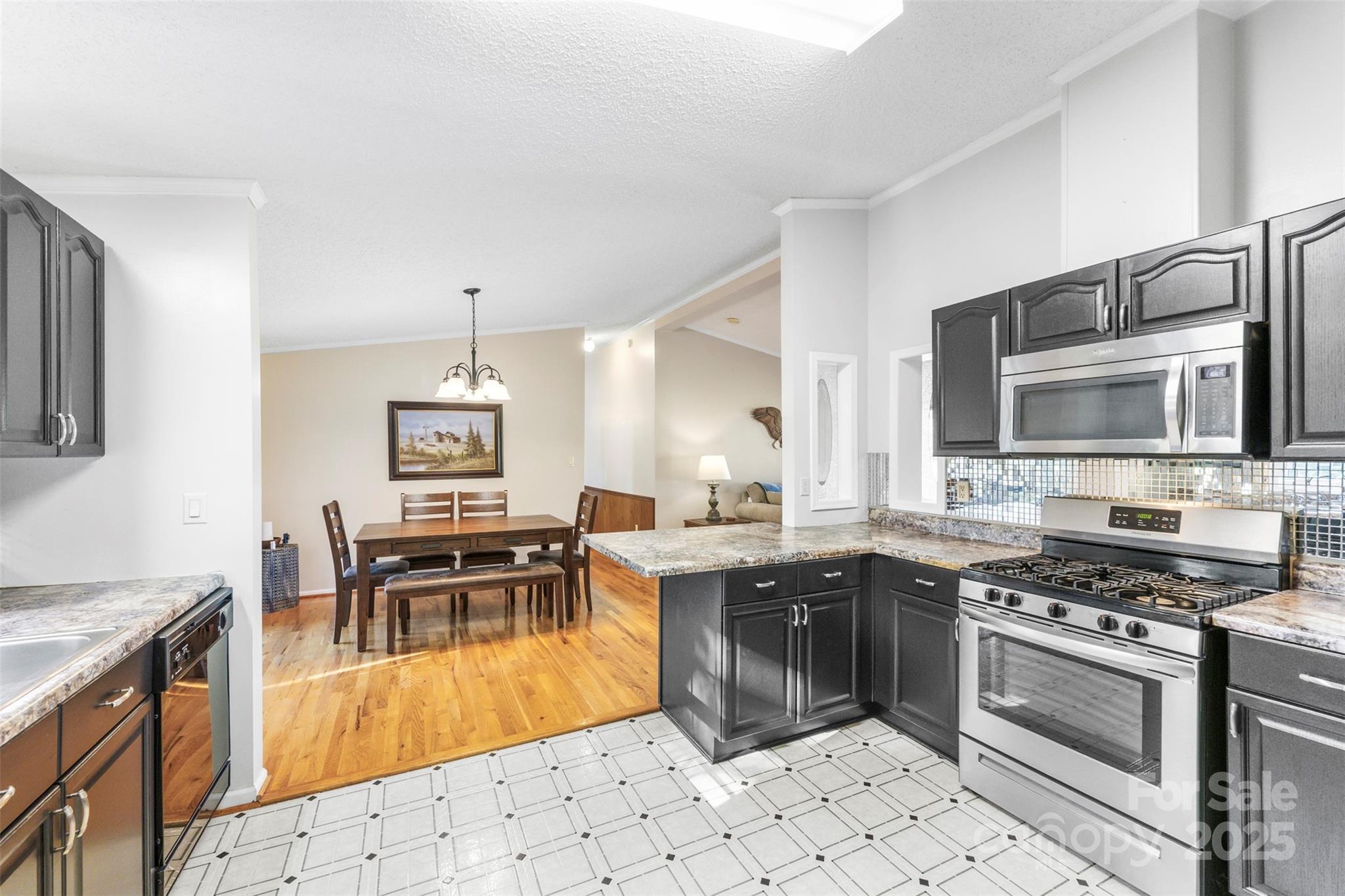 320 Huffstetler Lake Road Dallas, NC 28034 - Photo 15 of 47 a kitchen with stainless steel appliances kitchen island granite countertop a stove top oven a sink a dining table and chairs